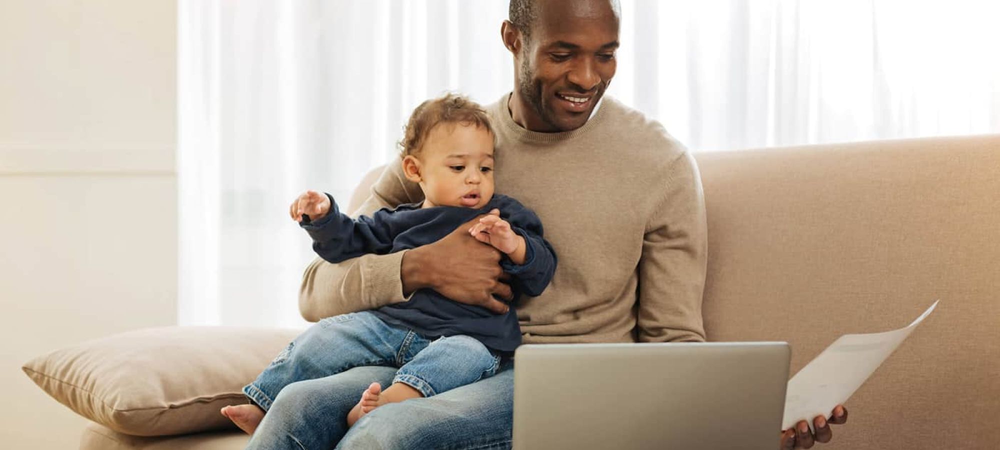 Man and baby home on couch